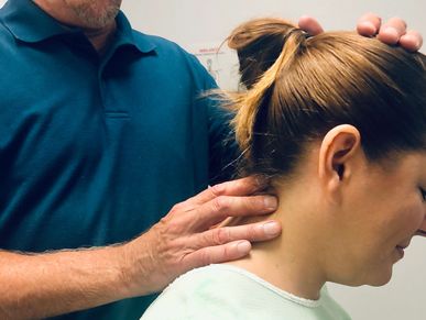 Dr. Schmidt examining a patient's neck (cervical spine).