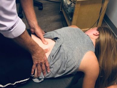 Dr. Schmidt massaging the lumbar spine (low back) of a patient.