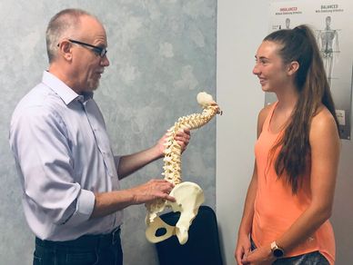 Dr. Schmidt discussing the Thoracic Spine (mid and upper back) with a patient.