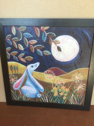 Moon gazing hare with full moon mainly painted in blues, yellows and white with a black frame