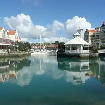 Serene waterfront with buildings and reflections.