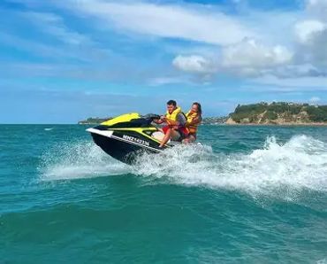 Two people riding a jet ski on the ocean.