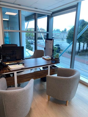 Modern office space with large windows and cozy seating.