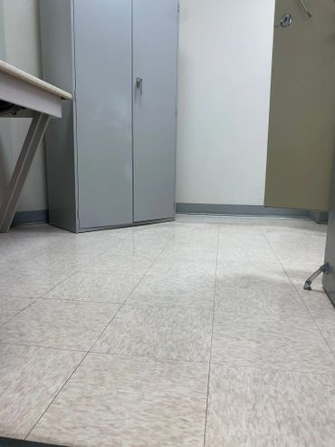 Office corner with a metal cabinet and tiled floor.