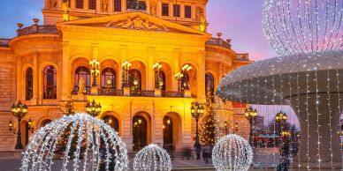 Illuminated historic building with festive light decorations at dusk.