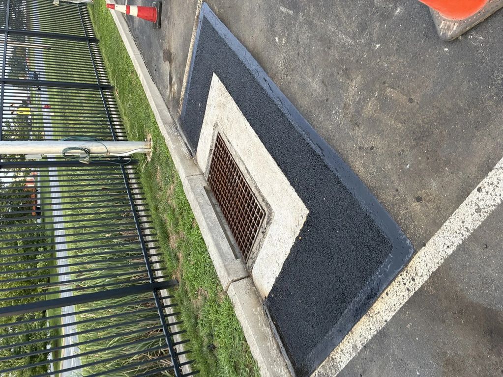 Newly paved area around a storm drain.