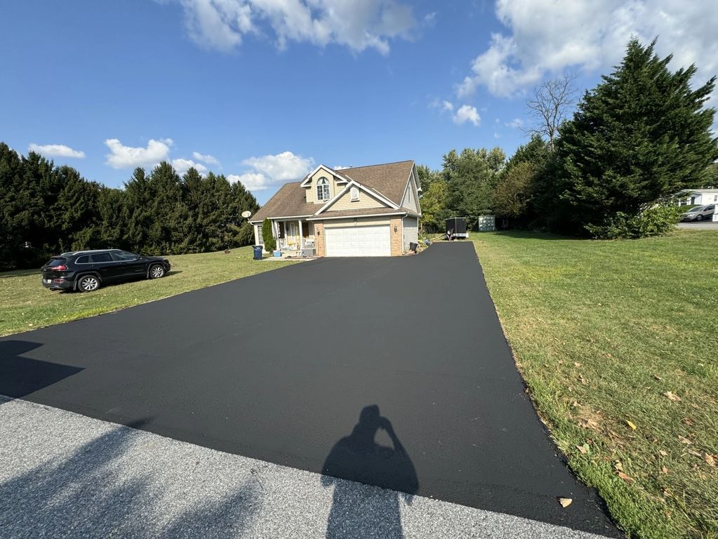 Driveway freshly paved in front of a suburban house.
