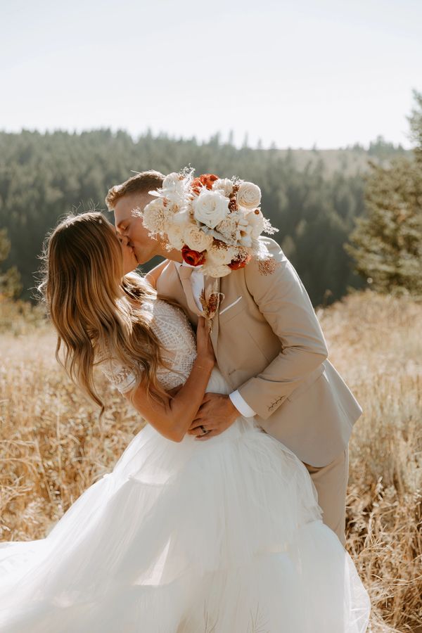 kelly canyon ski resort bride and groom kissing at the top of the mountain