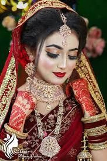 Traditional bride in ornate red attire and jewelry.