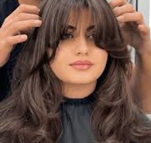 Woman with voluminous layered haircut being styled.
