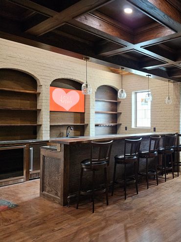 Cozy home bar with wooden accents and a brick fireplace.