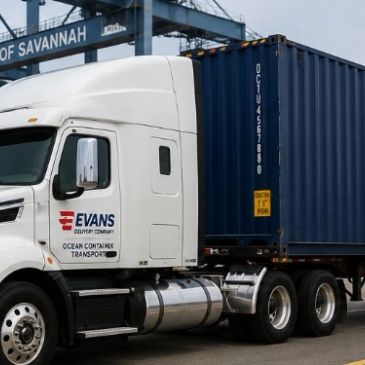 White Evans delivery truck with blue container at a shipping port.