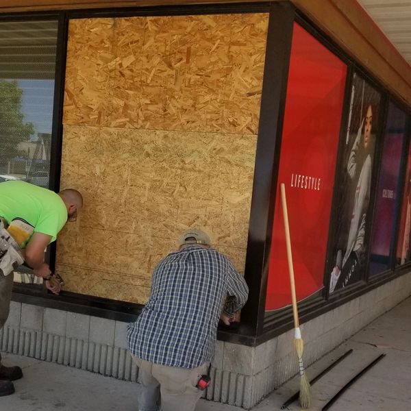 Two men boarding up an opening