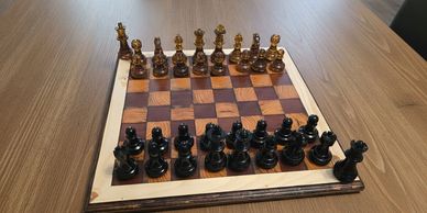 Made of a mix of common and exotic hardwoods, paired with resin pieces including an extra queen. Th