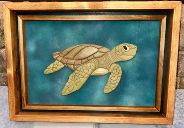 Framed 3D wooden sea turtle artwork on blue background.