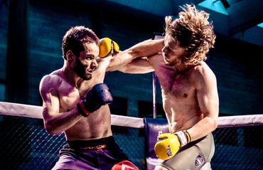 Two intense MMA fighters exchange powerful punches in the cage.
