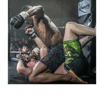 Two MMA fighters in intense ground combat inside a cage.