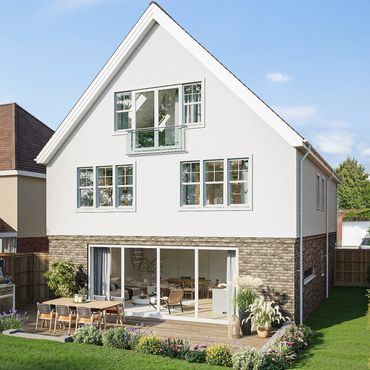 Modern two-story house with a garden patio and barbecue grill under a clear sky.