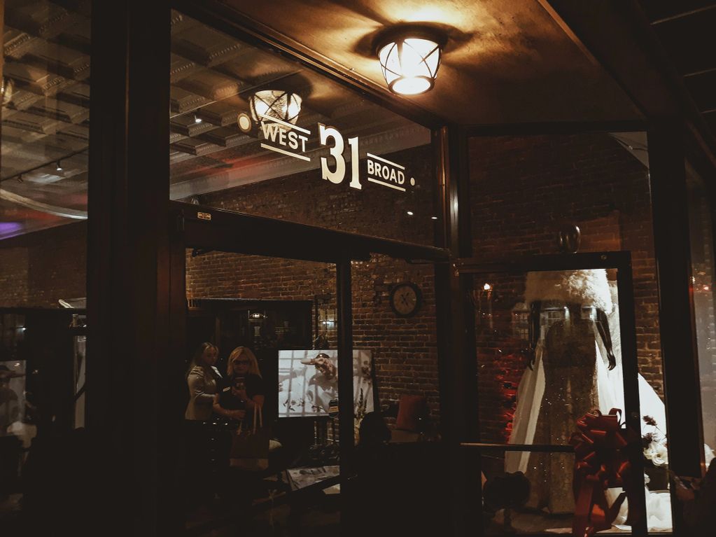 Exterior nighttime photo of Couture By Tess Bridal storefront windows