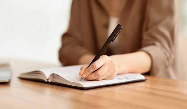 Cropped image of manager taking notes with pen