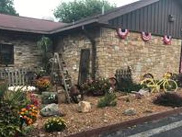 Stone building with garden and yellow bicycle.