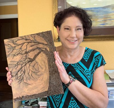 Kimberly LeClaire holding glue tree painting