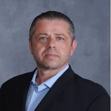Professional headshot of a serious man in a suit.