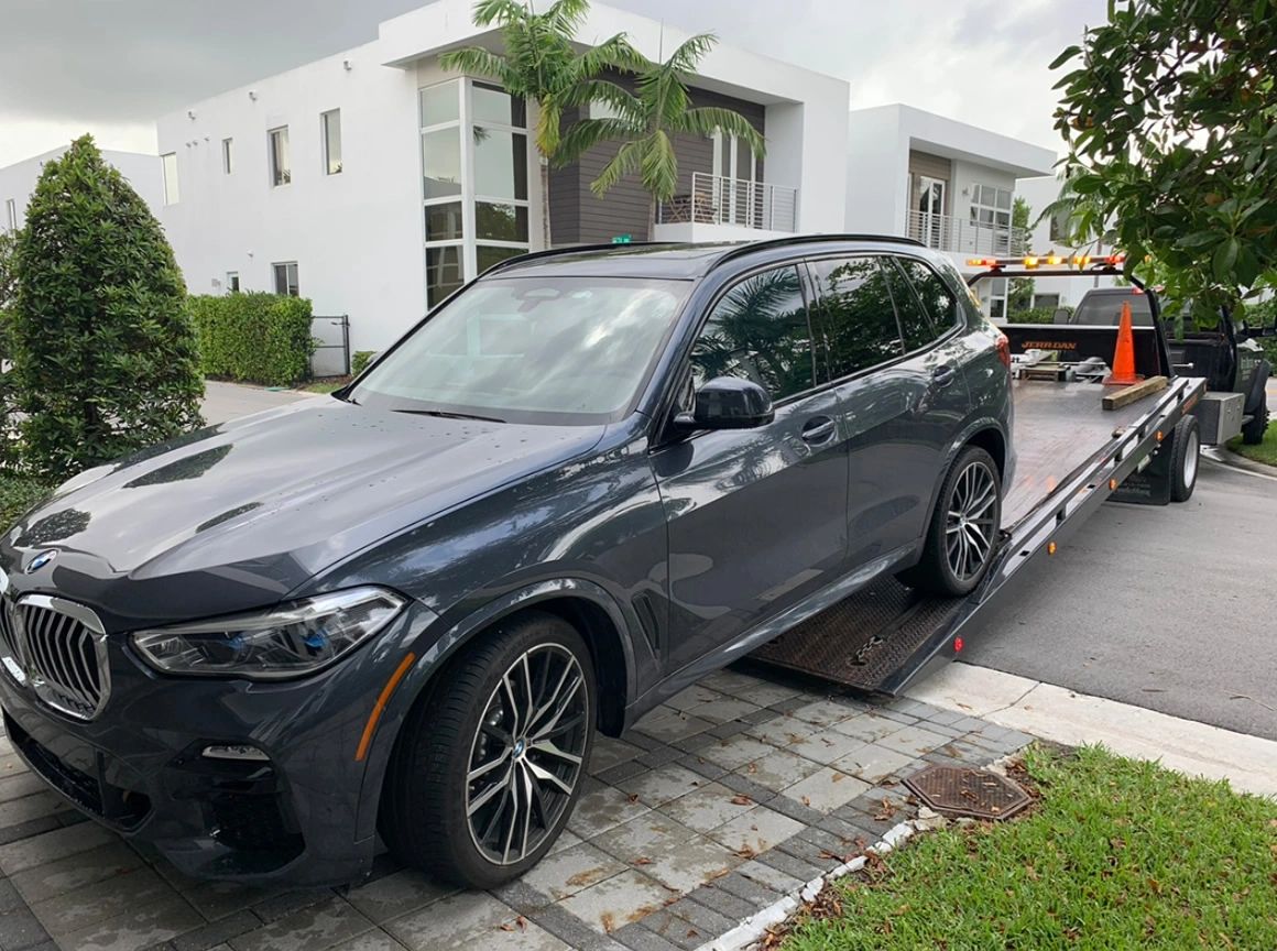 BMW Luxury SUV being towed by a flatbed in Doral