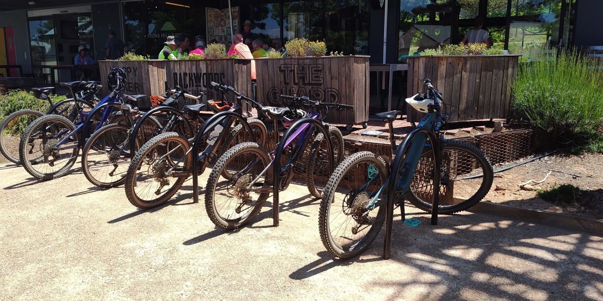 Row of mountain bikes parked outside a cafe.