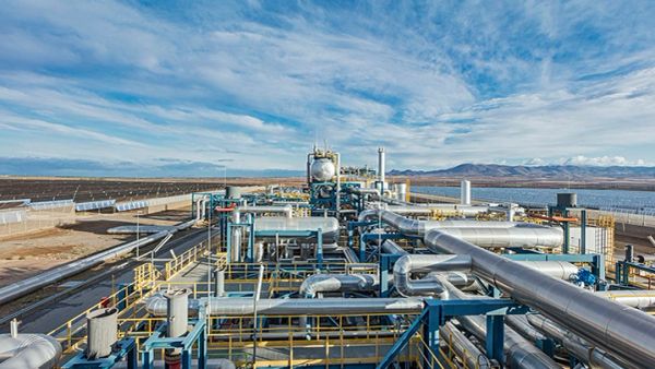 Industrial plant with extensive pipelines under a blue sky.