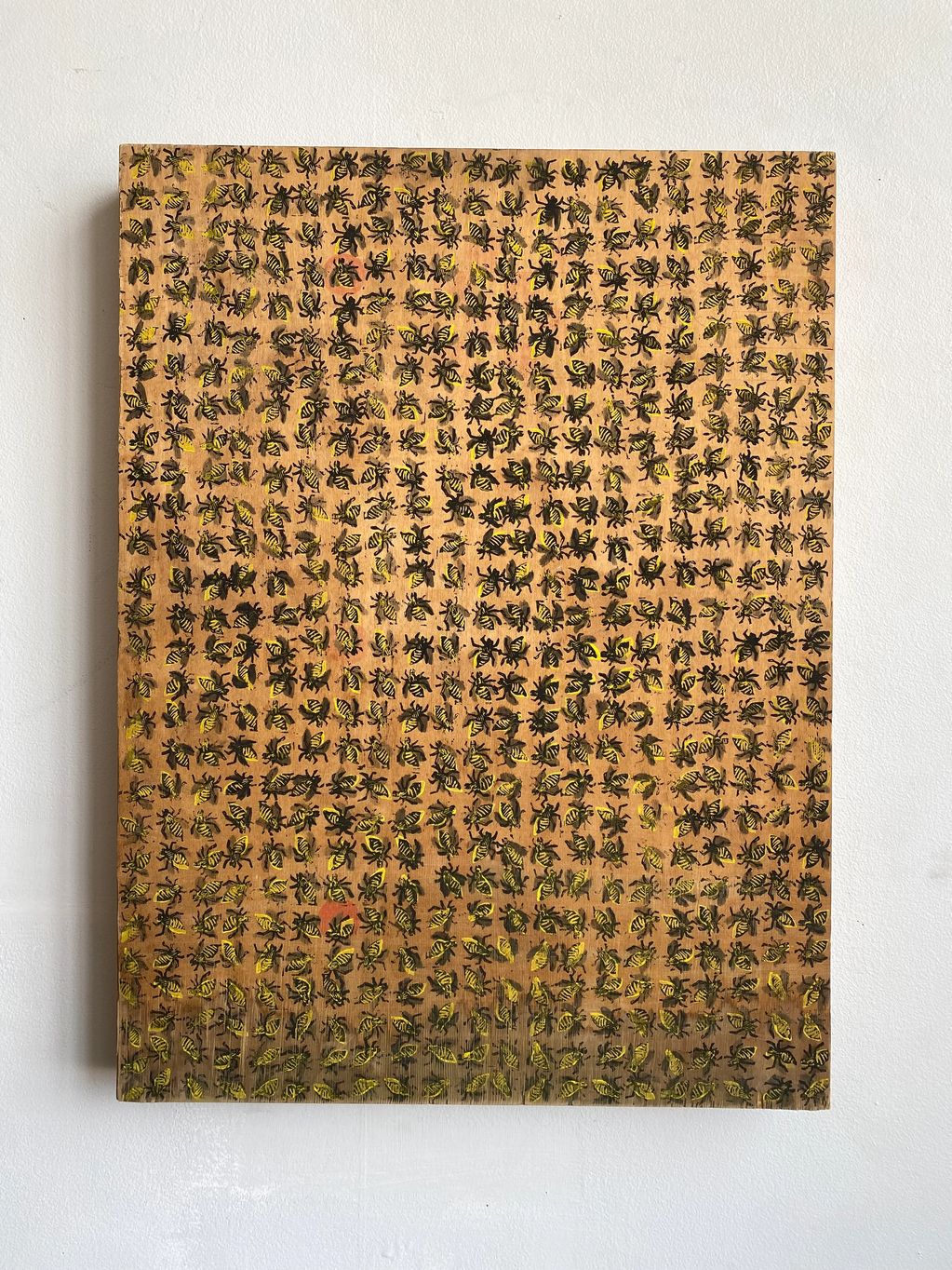 Wooden board covered with numerous yellow and black bee illustrations.