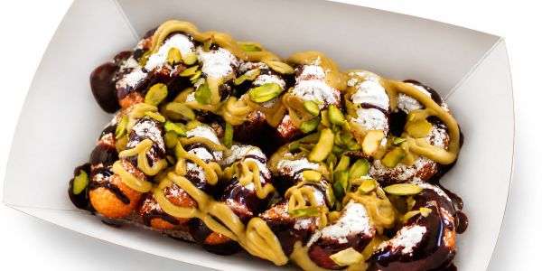 Delicious dessert topped with chocolate, peanut butter, powdered sugar, and pistachios.