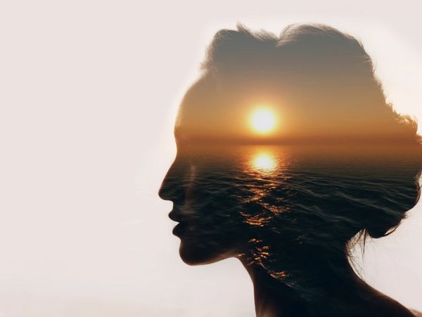 The concept of psychology. Sunrise and dreamy woman silhouette.

