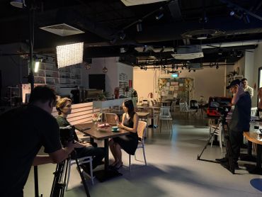 Filming interview scene in a café setting.
