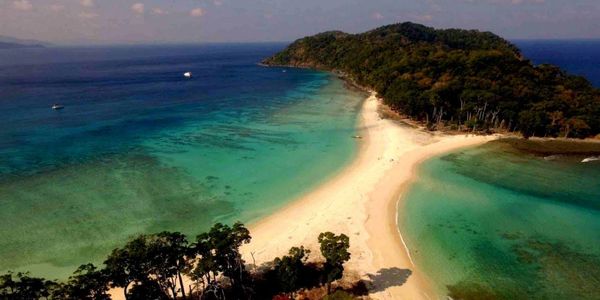 Aerial view of a tropical island with clear turquoise waters and sandy beaches.
