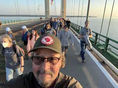 selfie of mike walking on the mackinaw bridge with other walkers in background