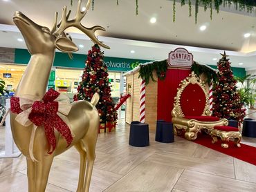 Traditional look Santa grotto featuring red and gold thumbing with fun details at Coast Plaza 2025.