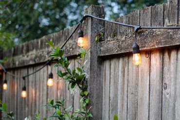 Festoon lights hanging on fence.