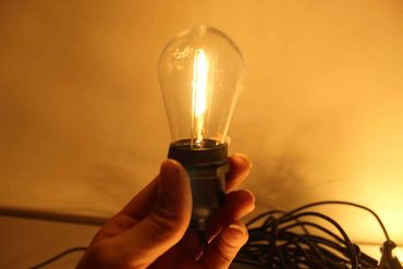 Single classic festoon light bulb lit up.