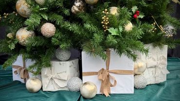 Closeup of luxurious Christmas present stack in white and natural colours of Christmas tree.