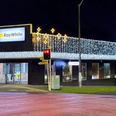 Cool white icicle lights on building in Glen Eden, Auckland.