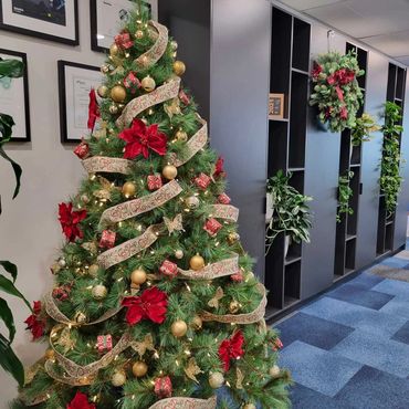 Gorgeous traditional red and gold with touch of green and natural look ribbon on office tree.