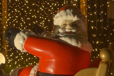 Santa closeup in front of fairy lights.