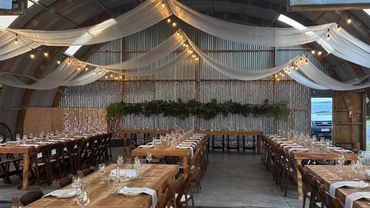 Indoor festoon light and sheer curtain canopy for rustic-chic wedding.