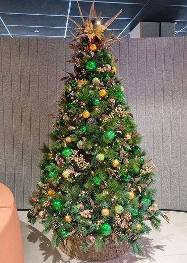 Bright green and gold native birds and berries themed Christmas tree in office.