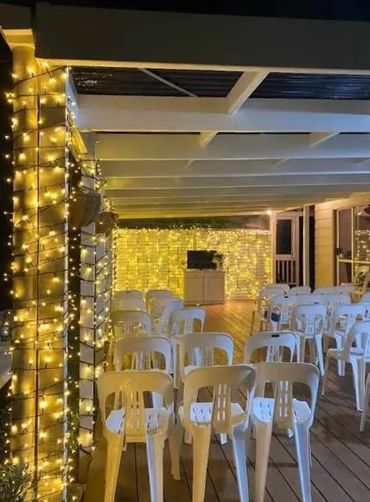 fairy lights on pillars and back wall of stage.