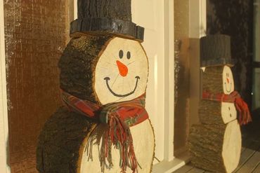 Closeup of log snowmen at night.