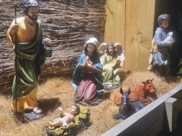 Closeup of nativity set with resin figures and handmade manger.
