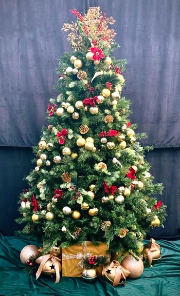 Gold bauble spiral tree with red Christmas flowers and luxury Christmas present bye with bells.