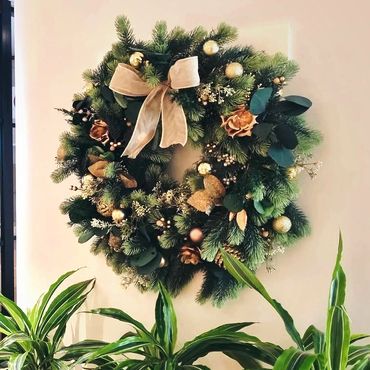 Gold floral Christmas wreath with preserved leaves with lush artificial pine sprigs.